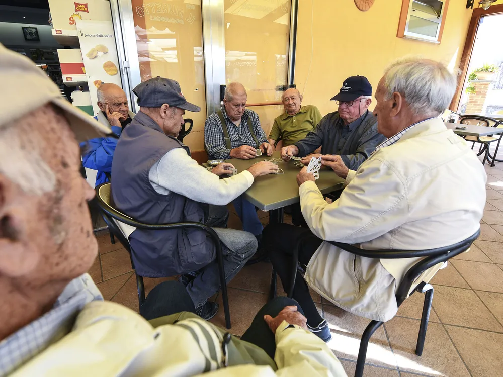 A group of old men playing cards in a bar